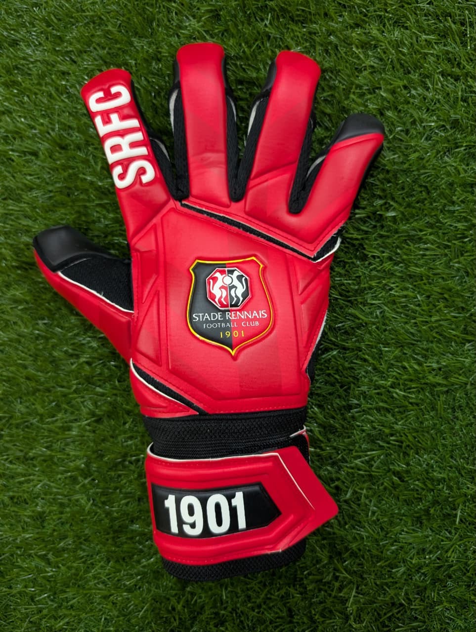 Gant Stade Rennais rouge et noir posé sur le terrain